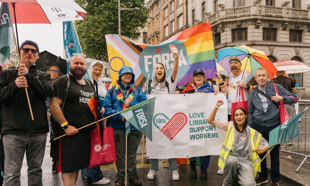 Fórsa LGBTQIA+ members and allies, soaked from the rain but full of fun, group photo at Pride 2025